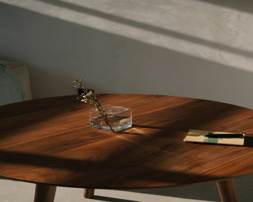 Open book and glasses on a wooden table with soft lighting
